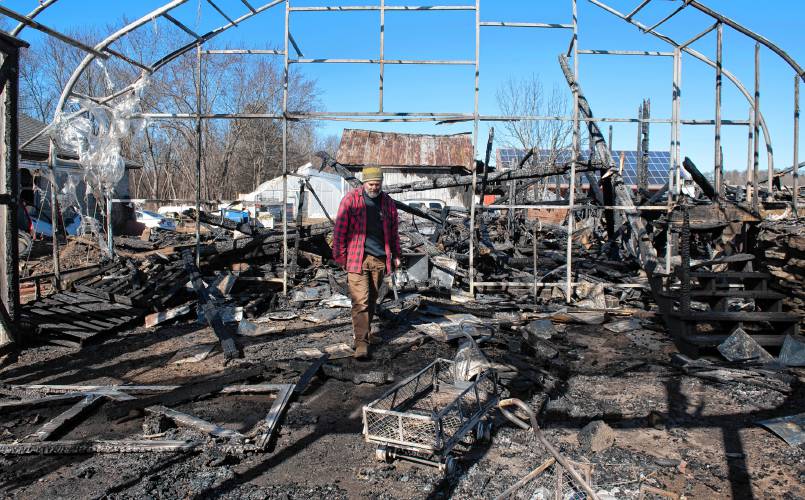 Ryan Voiland, a co-owner of Red Fire Farm in Granby, walks through the burnt green house on Feb. 20, 2024, and talks about the damage from a fire at the farm and what it will take to rebuild.