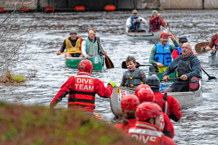 Members of the dive team assist paddlers arriving at the finish line during the 59th running of the River Rat Race from Athol to Orange on Saturday.