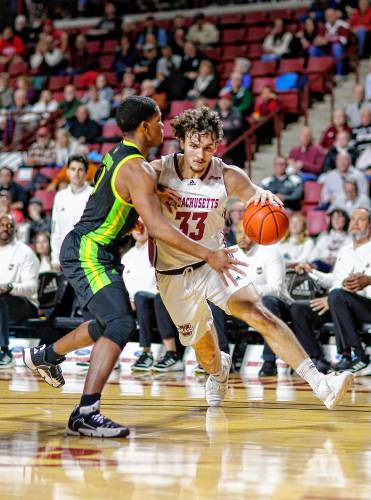 UMass forward Matt Cross (33) drives the ball against South Florida’s Chris Youngblood (3) earlier this season at the Mullins Center in Amherst.