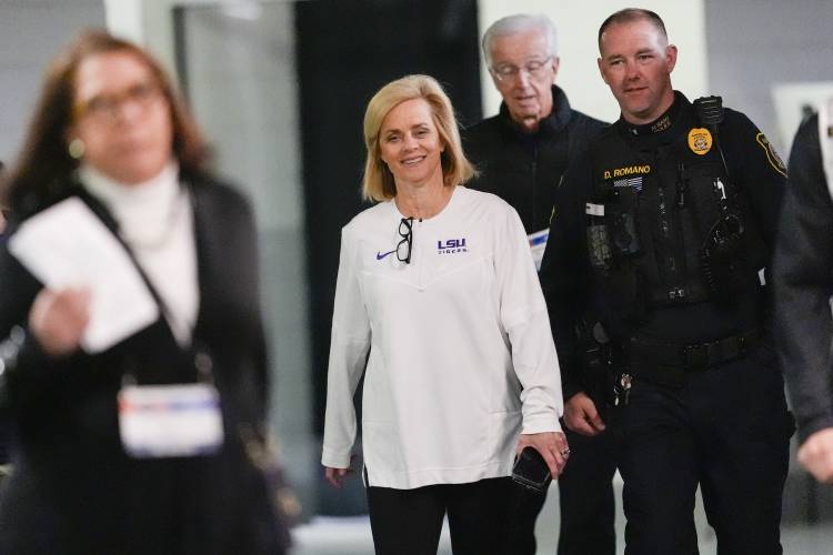 LSU head coach Kim Mulkey, center, is escorted to a news conference at a women's college basketball NCAA Tournament in Albany, N.Y., Friday, March 29, 2024. (AP Photo/Mary Altaffer)