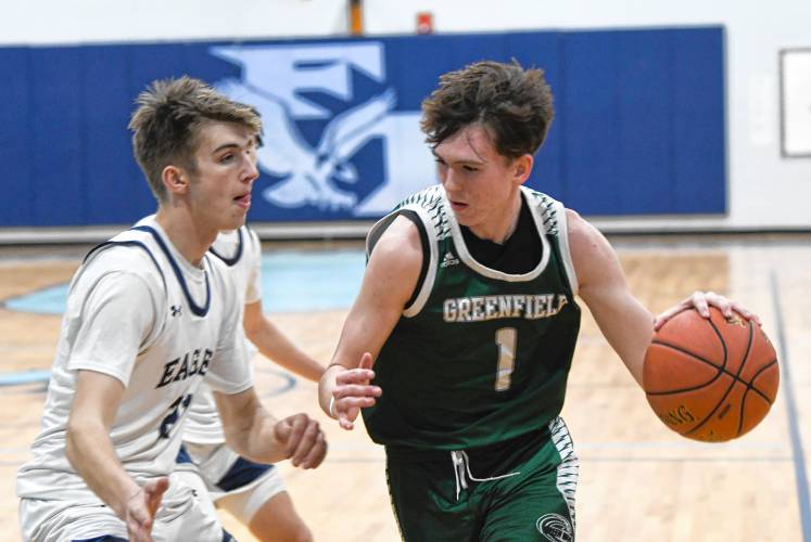 Greenfield’s Jacob Blanchard (1) drives while defended by Franklin Tech’s Robert Belvai during the Green Wave’s 80-45 win on Thursday night in Turners Falls. 