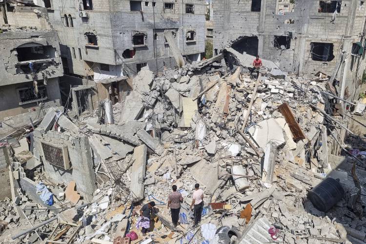 Palestinians look at the destruction after an Israeli airstrike in Rafah, Gaza Strip, on Monday.