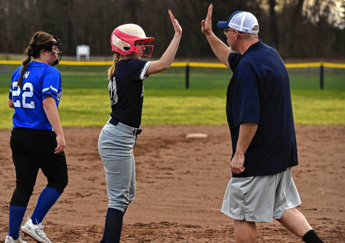 Franklin Tech’s Kyra Goodell (21) high-fives head coach Joe Gamache on third base against Wahconah during the Eagles’ season-opening victory in Turners Falls on Monday.