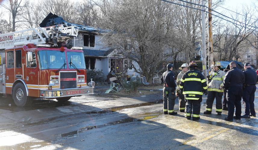 Fire crews clean up after an overnight fire gutted the house at 99 West River St. in Orange on Wednesday, Dec. 13.