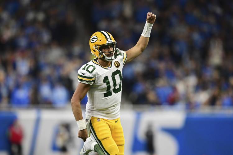 Green Bay Packers quarterback Jordan Love runs up field after throwing a touchdown to wide receiver Christian Watson during the second half of an NFL football game against the Detroit Lions, Thursday, Nov. 23, 2023, in Detroit. (AP Photo/David Dermer)