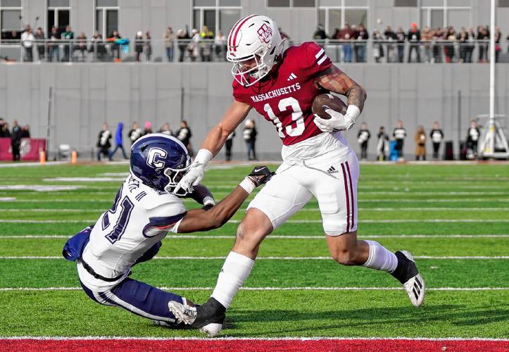 UMass tight end Gino Campiotti (13) stiff-arms UConn’s Lee Molette III (21) on his way to the end zone for a touchdown during the Minutemen’s 31-18 loss on Saturday at McGuirk Alumni Stadium in Amherst.