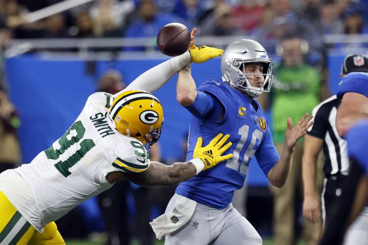 Green Bay Packers linebacker Preston Smith (91) strips the ball away from Detroit Lions quarterback Jared Goff (16) during the first half of an NFL football game, Thursday, Nov. 23, 2023, in Detroit. (AP Photo/Duane Burleson)
