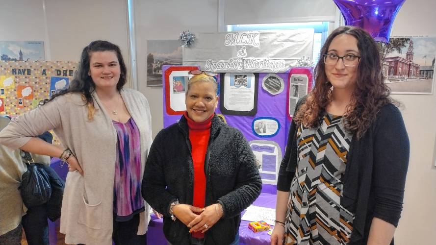 Aida Feliciano (center), a family support worker with Valuing Our Children (VOC), in front of her display about Dr. Martin Luther King Jr.'s impact on the people of Puerto Rico. Standing with her are Kayla Bosselait (right) and Angelina Howard, both of VOC. 