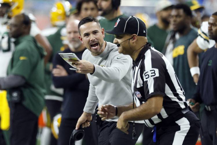 Green Bay Packers head coach Matt LaFleur argues a call with down judge Mike Carr (63) during the first half of an NFL football game against the Detroit Lions, Thursday, Nov. 23, 2023, in Detroit. (AP Photo/Duane Burleson)