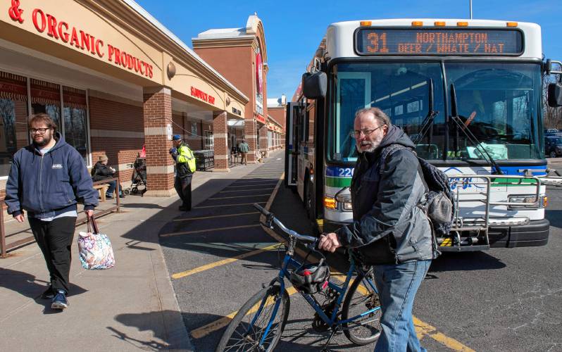 David Grace of Greenfield gets his bike off the bus at the Big Y stop in Northampton. “These buses are very important for grocery shopping,” he said.
