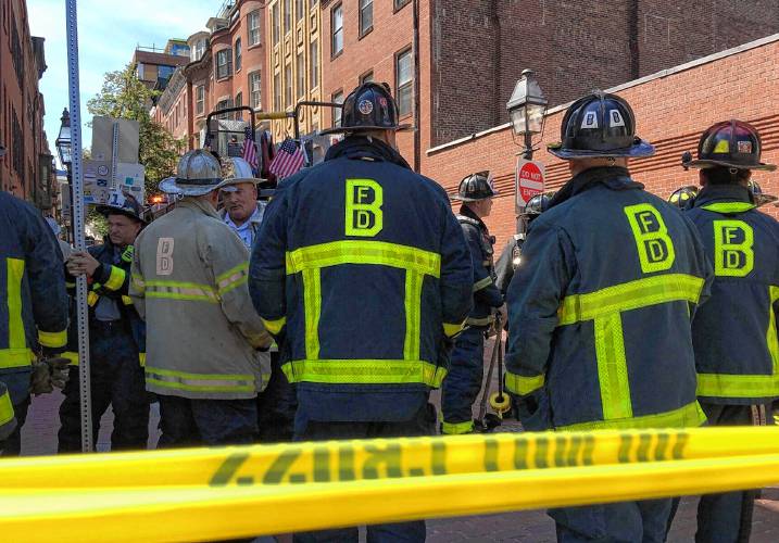 Boston firefighters gathered at Temple and Cambridge streets Monday, Aug. 5, 2019, just down the hill from the State House, after workers struck a gas main.