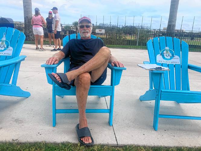 Leverett's Jerry Daly settles into an Adirondack chair underneath the centerfield scoreboard for a game at CACTI Park of the Palm Beaches in West Palm Beach, Fla.