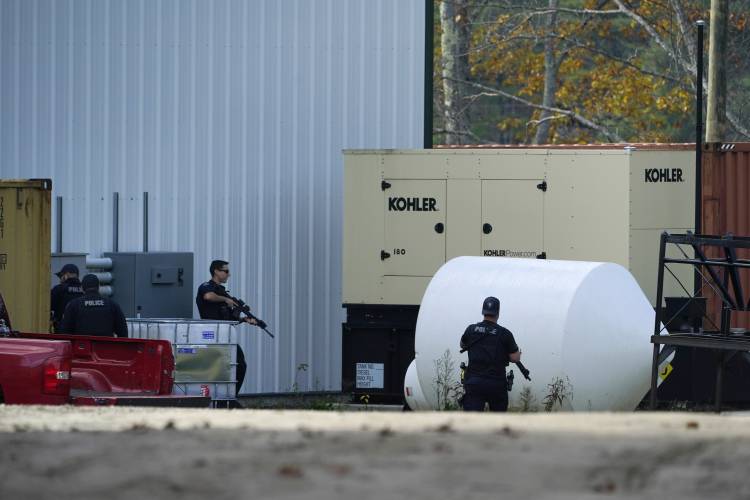 Law enforcement search a farm for the suspect in this week's deadly mass shootings, Friday, Oct. 27, 2023, in Lisbon, Maine. Police are still searching for the man who killed at least 18 in separate shootings at a bowling alley and restaurant in Lewiston on Wednesday. (AP Photo/Robert F. Bukaty)