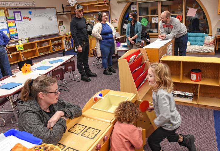 Warwick Community School staff members Stephanie Cross, at lower left, and Carlene Murray, top center with mask, speak with parents and students during an open house in the kindergarten and first grade classroom on Monday night.