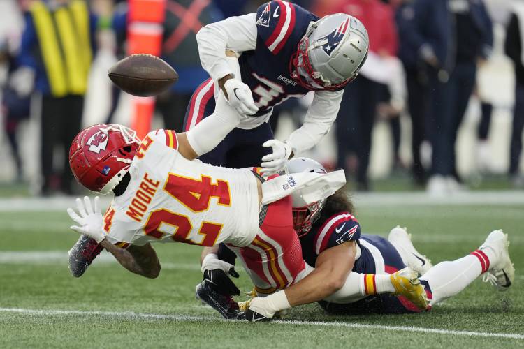 Kansas City Chiefs wide receiver Skyy Moore (24) is tackled by New England Patriots cornerback Jonathan Jones (31), top, and linebacker Jahlani Tavai (48), right, during the second half of an NFL football game, Sunday, Dec. 17, 2023, in Foxborough, Mass. (AP Photo/Charles Krupa)