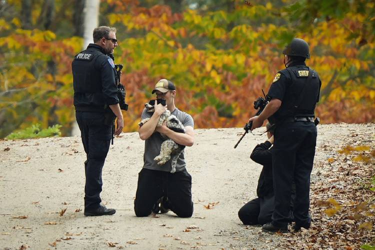 Law enforcement officers temporarily detain people as a manhunt continues in the aftermath of a mass shooting, in Durham, Maine, Friday, Oct. 27, 2023. Authorities are scouring hundreds of acres of family-owned property, sending dive teams to the bottom of a river and scrutinizing a possible suicide note in the second day of their intensive search for an Army reservist accused of fatally shooting several people in Maine. (AP Photo/Matt Rourke)