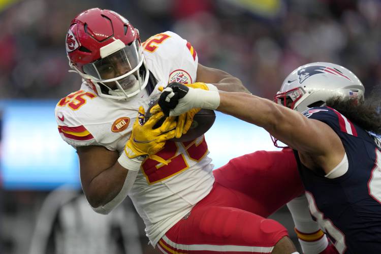 Kansas City Chiefs running back Clyde Edwards-Helaire (25) scores a touchdown on a pass from quarterback Patrick Mahomes, not shown, as New England Patriots linebacker Jahlani Tavai (48) tries to defend in the second half of an NFL football game, Sunday, Dec. 17, 2023, in Foxborough, Mass. (AP Photo/Charles Krupa)