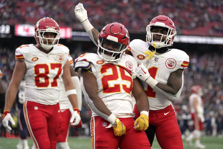 Kansas City Chiefs running back Clyde Edwards-Helaire (25) celebrates after his touchdown with tight end Travis Kelce (87) and running back Jerick McKinnon (1) during the second half of an NFL football game against the New England Patriots, Sunday, Dec. 17, 2023, in Foxborough, Mass. (AP Photo/Charles Krupa)