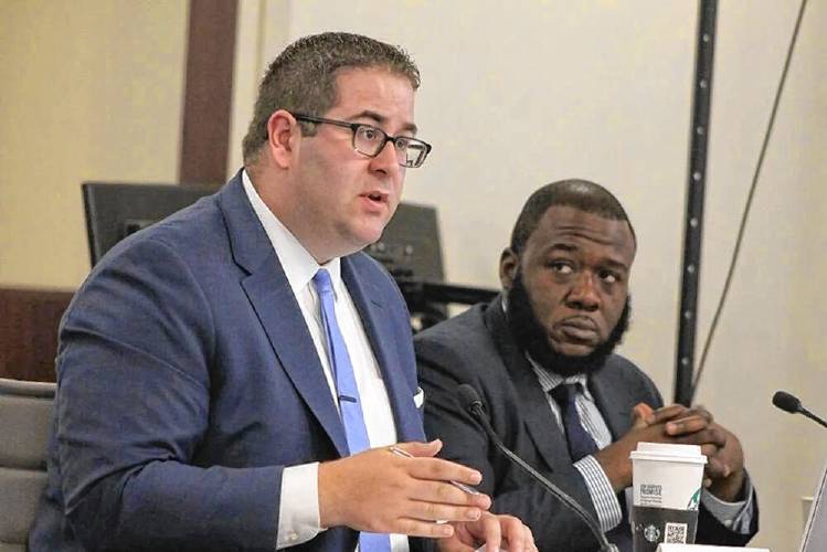 Executive Director Shawn Collins (left) speaks at a Cannabis Control Commission meeting in 2018. 