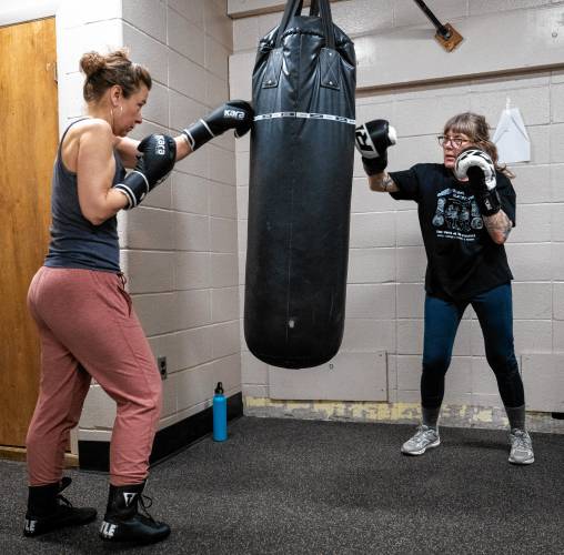 Irene McGarrity, left, and Nina Rossi train on a heavy bag during a women's boxing class at Franklin County's YMCA in Greenfield.