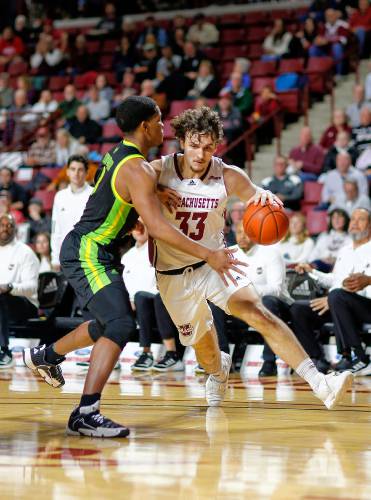 UMass forward Matt Cross (33) drives the ball against South Florida’s Chris Youngblood (3) in the second half Saturday at the Mullins Center in Amherst.