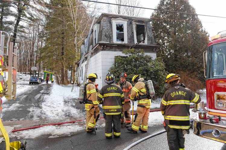 Fire fighters outside a two story gambrel style home that was the scene of a two alarm fire Wednesday morning on Mechanic Street in Orange. 