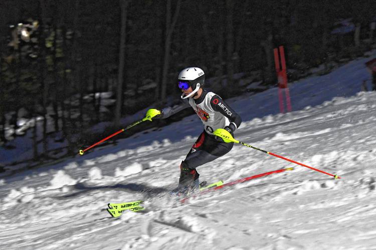 A racer navigates the slalom course during an evening high school ski meet at Berkshire East.