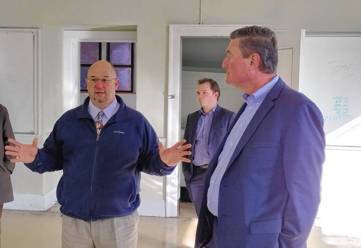 Athol Town Manager Shaun Suhoski (at left )speaks with Housing and Livable Communities Secretary Ed Augustus about plans to turn the former Riverbend and Bigelow schools into senior and affordable housing.