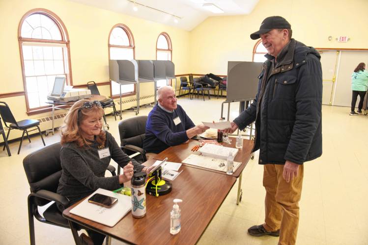 Susan Tandy Songer and Jeff Cole check in Orange resident Larry Fisher for the Town Election on Monday.