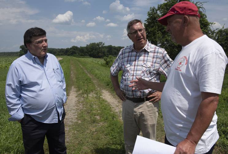Bernie Smiarowski talks with state Sen. Marc Pacheco, D-Taunton, and Sen. Michael Rodrigues, D-Westport, during a visit to the site of flooding at Teddy Smiarowski Farm in Hatfield to announce relief funding in late July. With an initial $10,000 from the Farm Resiliency Fund, Teddy Smiarowski Farm can cover some of its losses.