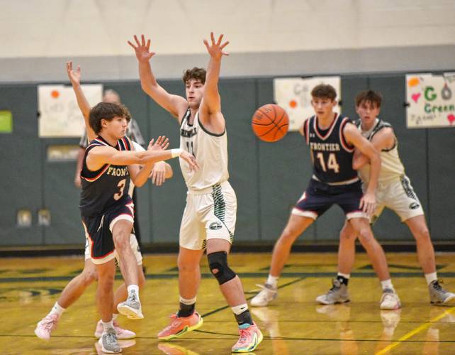 Frontier’s Nico Fasulo passes while defended by Greenfield’s Jonathan Breor during Hampshire League South action at Nichols Gymnasium in Greenfield on Tuesday evening.