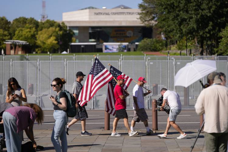 People gather across the street from the National Constitution Center, the site of tonight's presidential debate between Republican presidential nominee former President Donald Trump and Democratic presidential nominee Vice President Kamala Harris, Tuesday, Sept. 10, 2024, in Philadelphia.