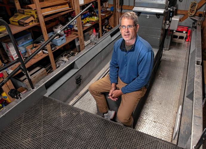 Ken Sprankle, project leader of the U.S. Fish & Wildlife Service’s Connecticut River Fish and Wildlife Conservation Office, sits on a boat stored in the garage at the office in Sunderland that is used to collect data on the population of juvenile shad.