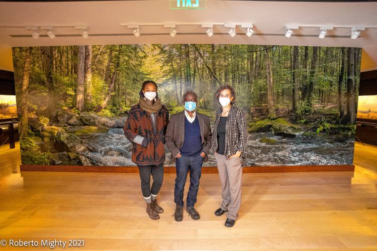 A mural honoring the legacy of the Nipmuc people who lived on and cared for the land which is now Harvard Forest was unveiled at Fisher Museum in 2021. From left are Nia Holley, who was involved in creating the mural, photographer Roberto Mighty, and Clarisse Hart, director of education and research for Harvard Forest and director of the Fisher Museum.