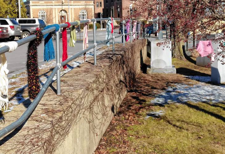 Scarves, each awaiting a new owner, line the railing near the Athol Area YMCA during the “scarf bombing” held in January 2023. The distribution of hats, scarves and mittens—which has been held for the last decade—will be held on Jan. 7. 
